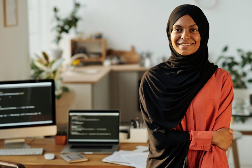 Young black woman in hijab in front of a computer - Black Women In Tech, Madison Ave Magazine