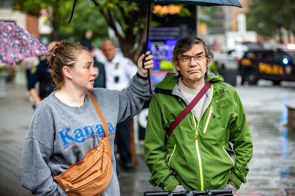 Two protestors look on during the event in thew rain